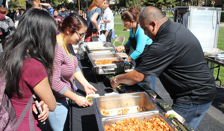 A photo of Founders Day celebration attendees getting tacos on the quad in 2014.